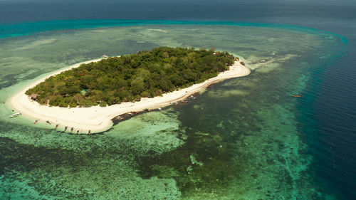 Small tropical island on an atoll with sandy beach  by coral reef . camiguin, philippines, mindanao