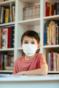 Portrait of boys wearing flu mask while studying at home