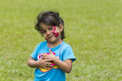 Portrait of girl with face paint standing on field