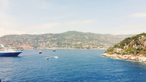 Scenic view of bay in city against sky