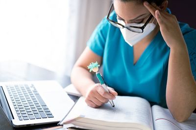 Midsection of woman reading book while sitting on table