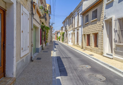 Empty road along buildings