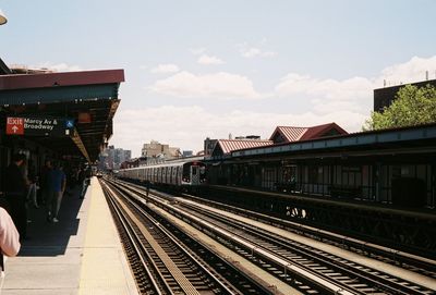 Railroad tracks in city against sky