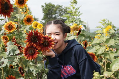 Portrait of cute girl with sunflower amidst plants