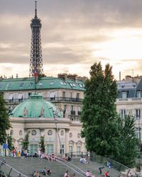 People at town square against cloudy sky