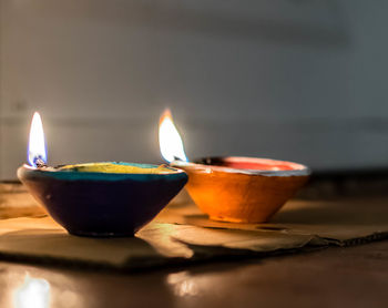 Close-up of lit diyas on floor