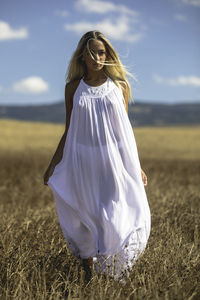 Midsection of woman on field against sky