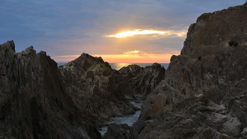 Scenic view of rock formations against sky during sunset