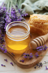 Glass of honey, honeycomb and lavender flowers