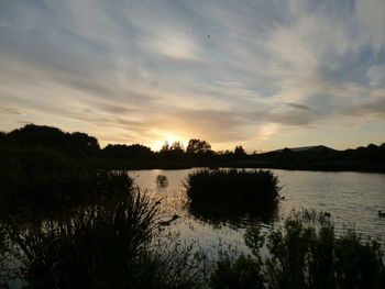 Scenic view of lake against sky during sunset