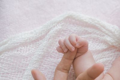 Low section of baby feet on bed