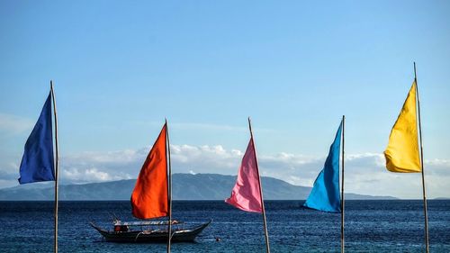 Boats in sea against blue sky