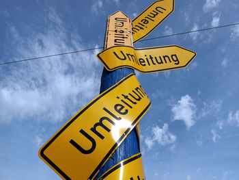 Low angle view of german road sign umleitung against sky - verkehrsschild umleitung