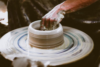 Midsection of man working on pottery wheel