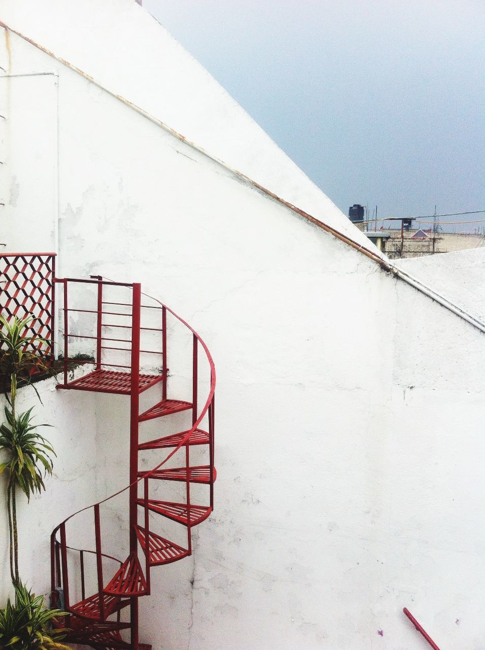 built structure, architecture, building exterior, wall - building feature, clear sky, day, railing, outdoors, house, no people, tree, steps, plant, protection, wall, water, sky, nature, safety, copy space