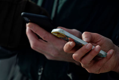 Cropped image of hands using mobile phone