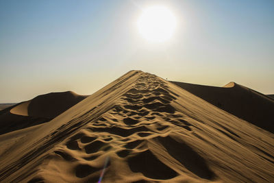 Sand dunes in desert against clear sky