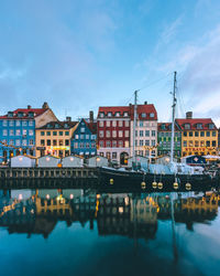 Reflection of buildings in river against sky