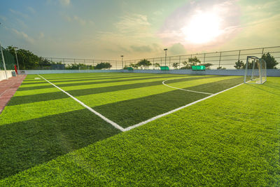 Soccer field against sky during sunset