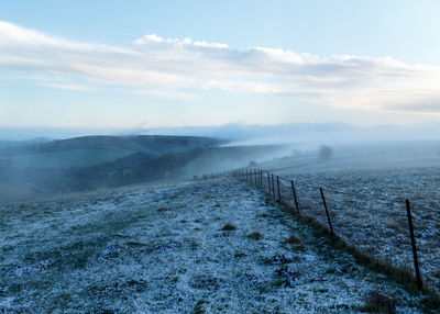 Scenic view of snow covered land against sky