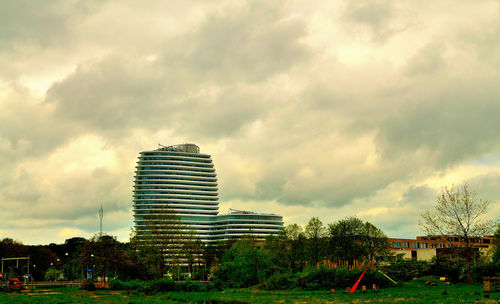 View of field against cloudy sky