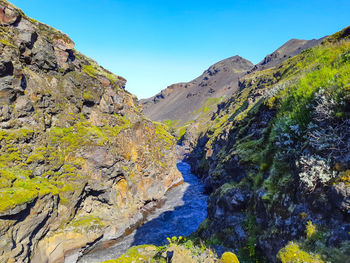 Scenic view of mountains against blue sky