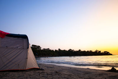 Scenic view of beach against clear sky during sunset