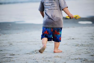 Low section of child standing on beach