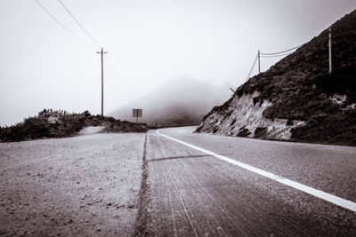 Road by mountain against clear sky