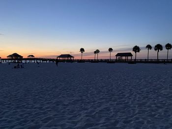 Scenic view of beach against clear sky during sunset