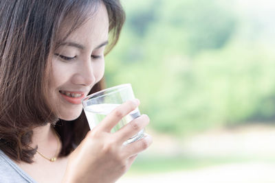 Portrait of a young woman drinking glass