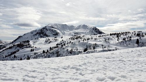 Scenic view of snow covered mountains against sky