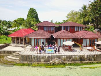 People outside house against buildings