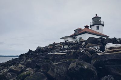 Lighthouse on rock against sea