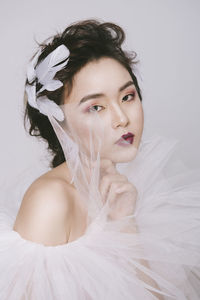 Portrait of beautiful young woman lying on bed