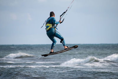 Full length of man surfing in sea against sky