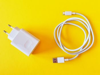 Close-up of electric lamp against yellow background