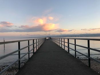 Pier over sea against sky during sunset