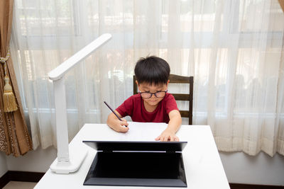 Full length portrait of a girl sitting on table