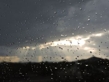 Close-up of water drops on cloudy sky during sunset