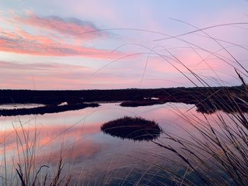 Scenic view of lake against sky at sunset