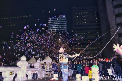 Crowd on illuminated city at night