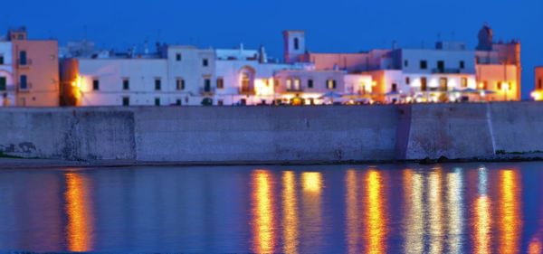 Reflection of illuminated building in water at night