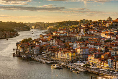 High angle view of townscape by river against sky during sunset