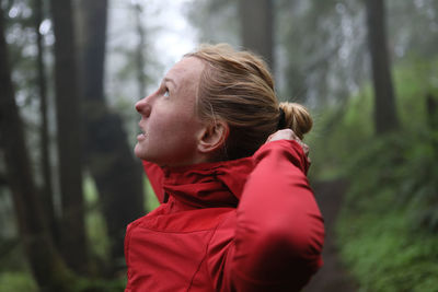 Side view of young woman in forest