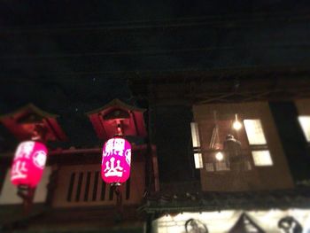 Low angle view of illuminated lanterns hanging at night