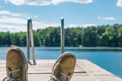 Low section of person on pier over lake