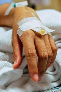 Close-up of woman hand with medical equipment on bed