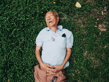 High angle view of senior man sleeping in lawn