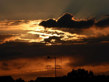 Low angle view of silhouette tree against dramatic sky